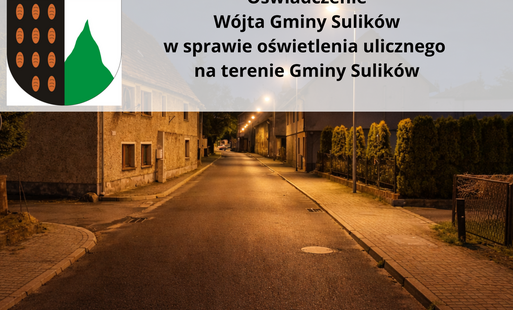 „Nocne zdjęcie spokojnej ulicy w niewielkiej miejscowości, oświetlonej ciepłym światłem latarni. Na pierwszym planie asfaltowa droga bez samochodów, po bokach chodniki i niska zabudowa jednorodzinna. Na górze grafiki półprzezroczysty panel z herbem gminy 